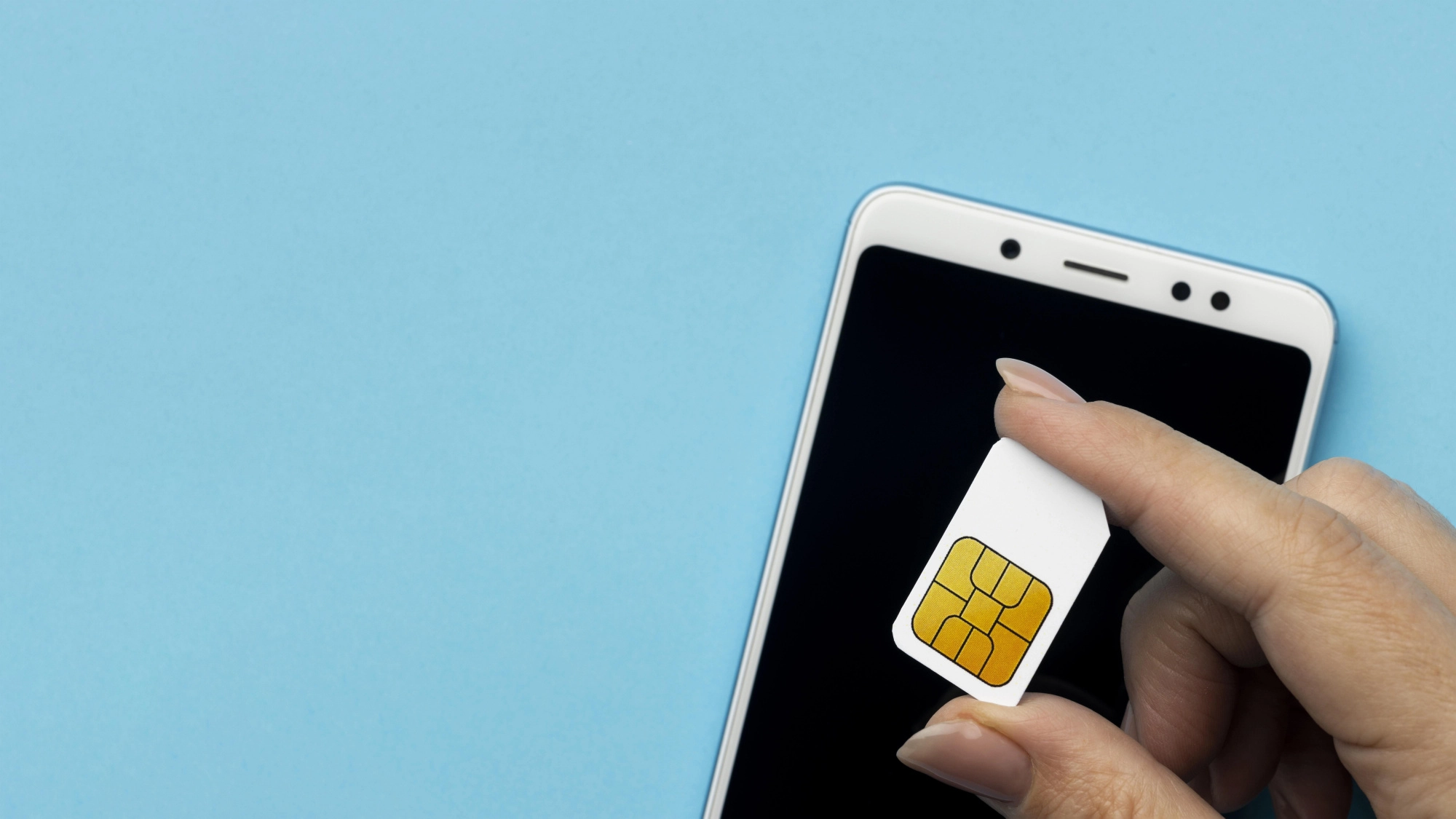 top-view-hand-holding-sim-card-with-smartphone-copy-space.jpg